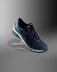 A navy ASICS Gel-Cumulus running shoe on a grey backdrop